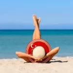 Young-Woman-Lying-On-A-Beach-In-Turkey-With-A-Turkey-Flag-Straw-Hat-Mediterranean-Coast.jpg