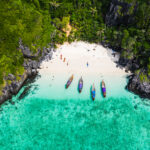 hi season boat and tourists on phiphi island Krabi Thailand aeri