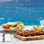 Greek food concept with a farmers salad in front of the Aegean sea