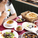 top view woman eats chicken soup with salads and cheese
