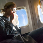 woman-blowing-nose-sneezing-airplane